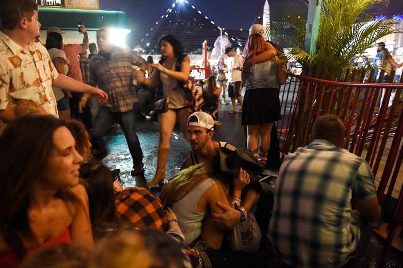 People run for cover at the Route 91 Harvest country music festival after a gunman began...