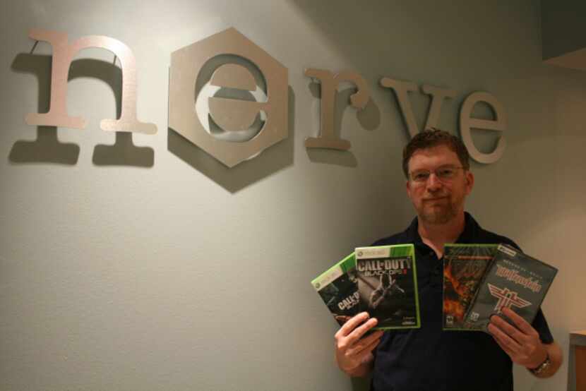 Nerve Software founder and president Brandon James holds up some of the popular game titles...