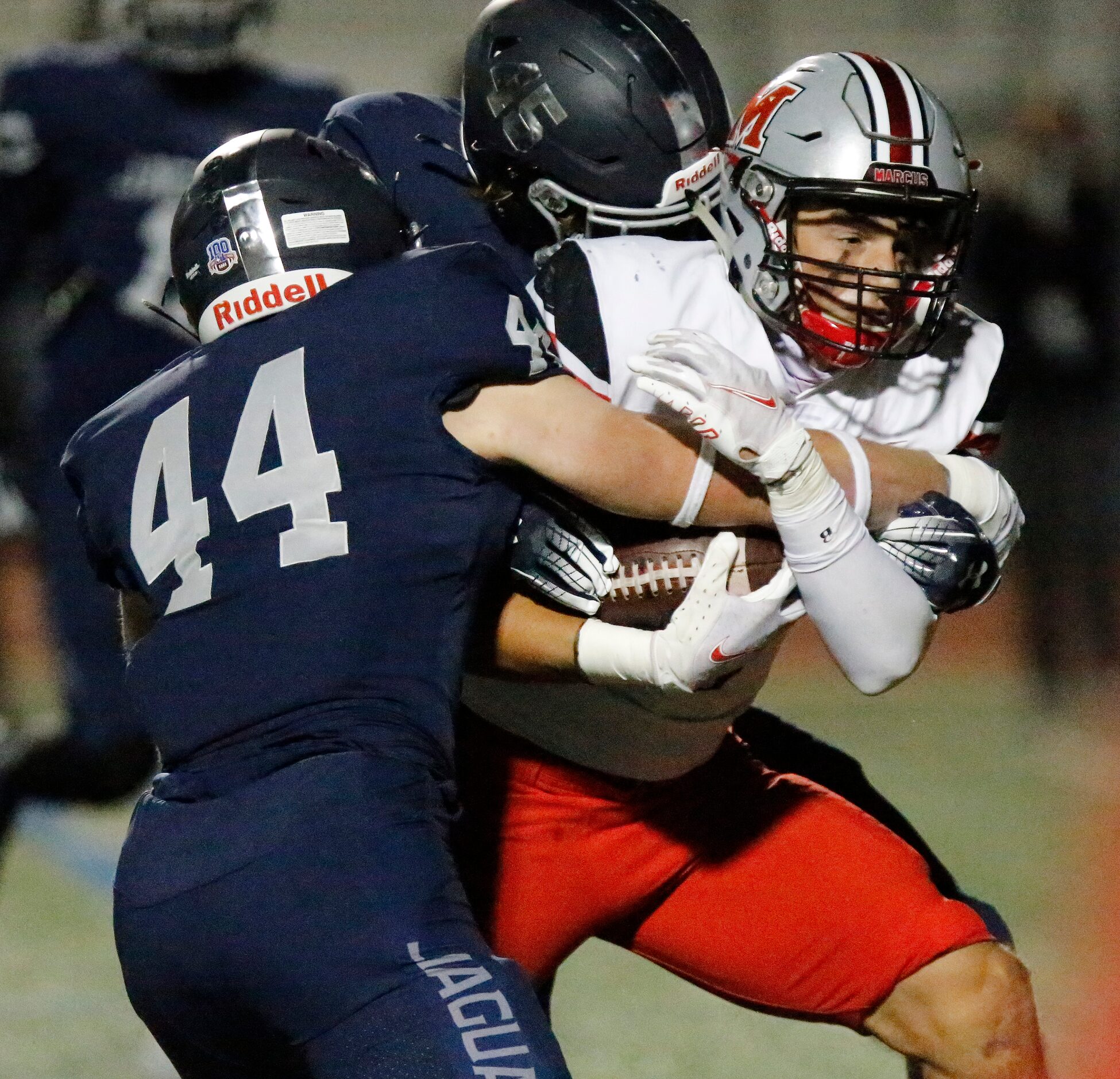 Flower Mound Marcus running back Tyler Schott (3) is tackled by Flower Mound High School...