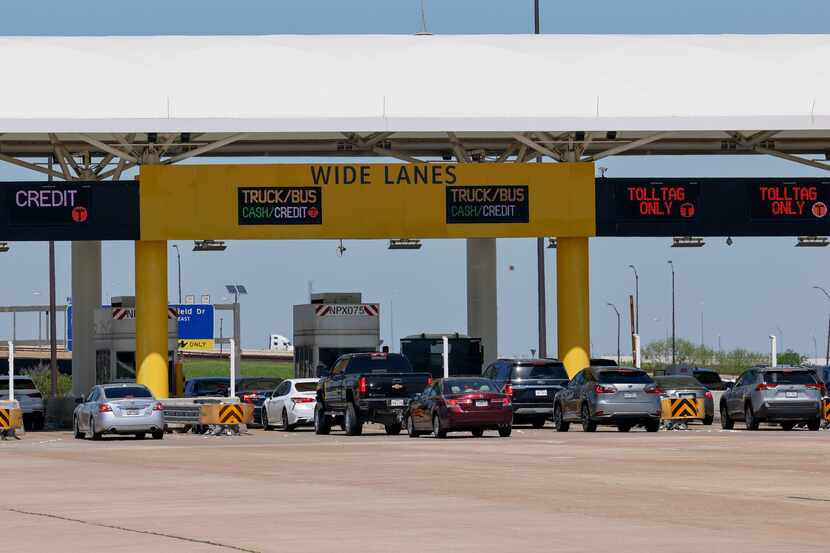 Travelers wait to pay at the north exit toll plaza at DFW International Airport, Friday,...