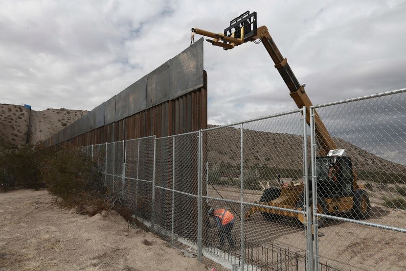 In this Nov. 10, 2016 file photo, workers raise a taller fence along the Mexico-US border...