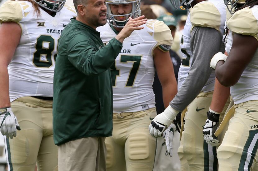 Baylor coach Matt Rhule talks to players during the first half of the NCAA college football...