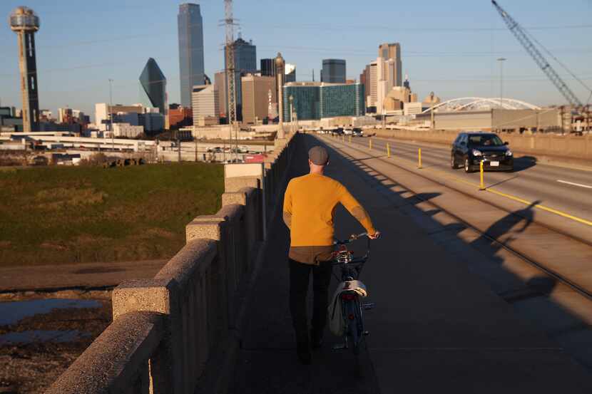 Jason Roberts, co-founder of Bike Friendly Oak Cliff, walks across the Houston Street bridge...
