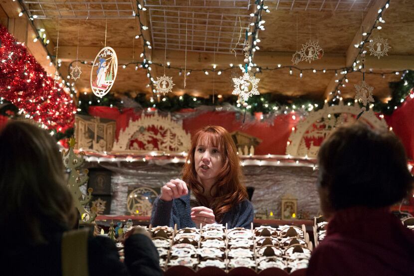 Vendor Christine Brady speaks with customers at the outdoor Christkindl Market in Arlington...