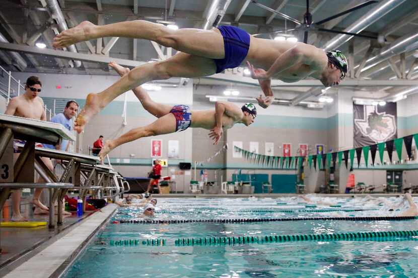 Southlake Carroll swimmers Jaykob Williams (foreground) and Kevin Repice leap from blocks to...