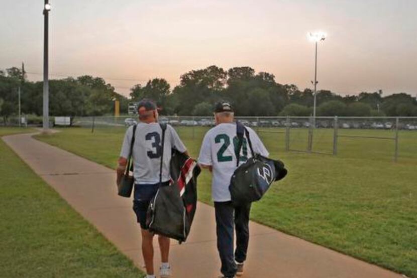 
Benton (left) walks to his car while visiting with an opponent after the teams’ doubleheader.
