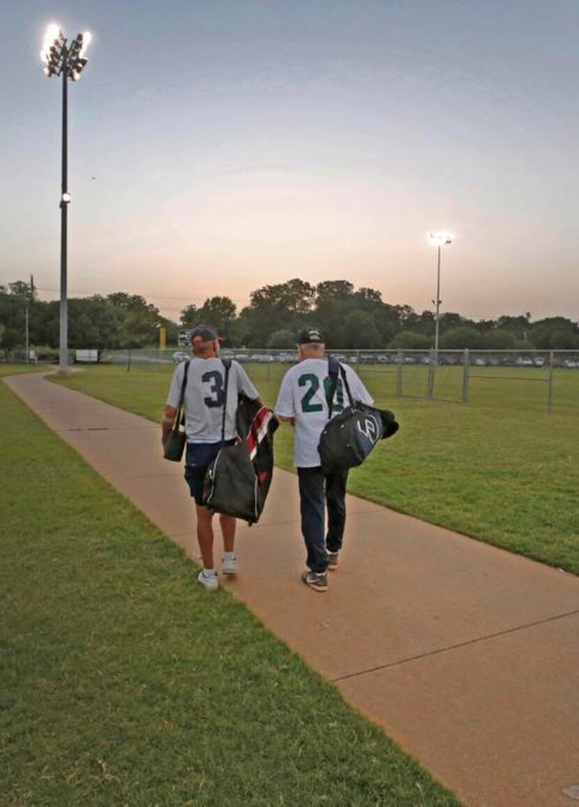 
Benton (left) walks to his car while visiting with an opponent after the teams’ doubleheader.
