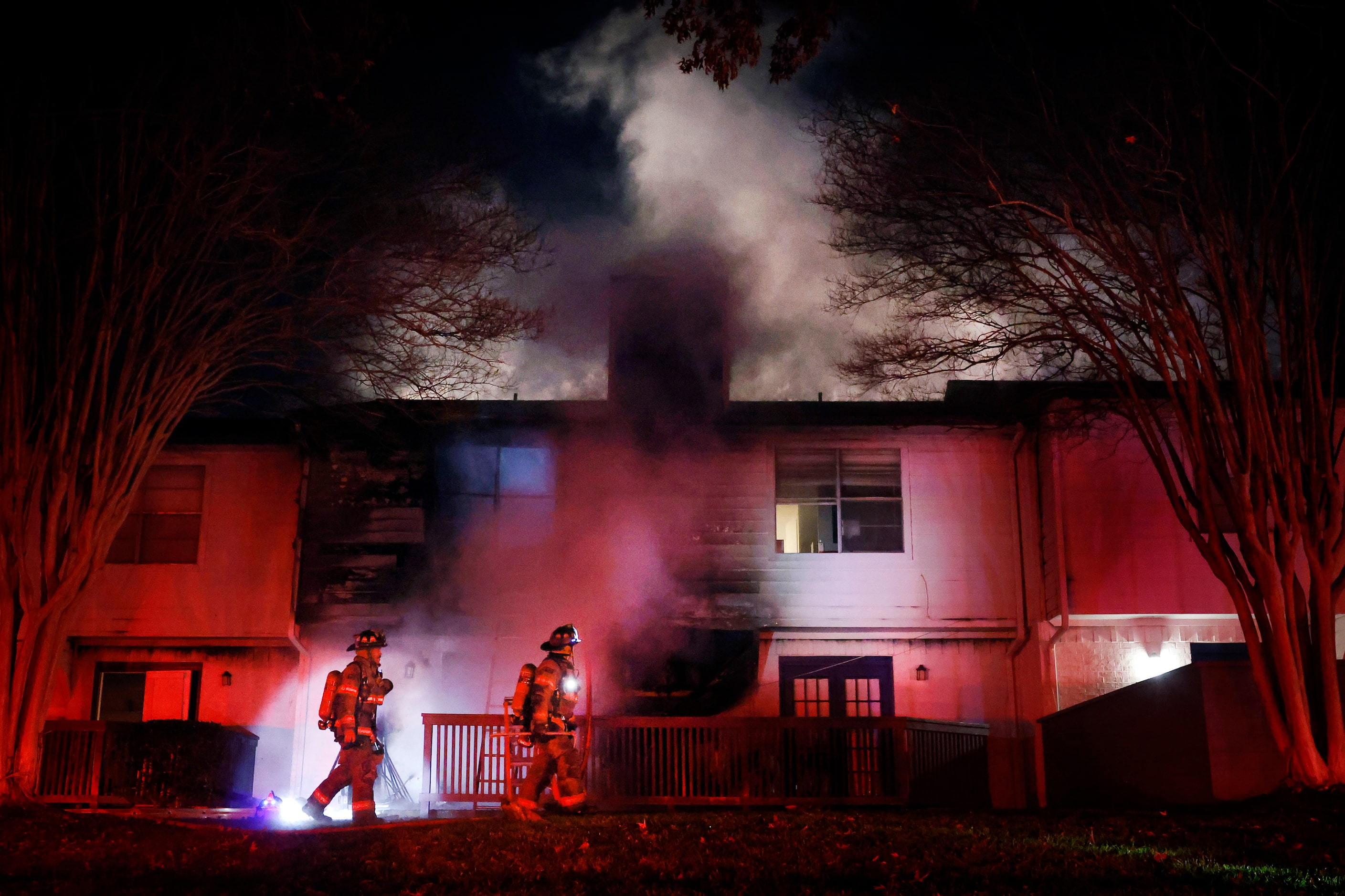 Arlington firefighters pass under the fire at the Rise North Arlington apartments along NE...