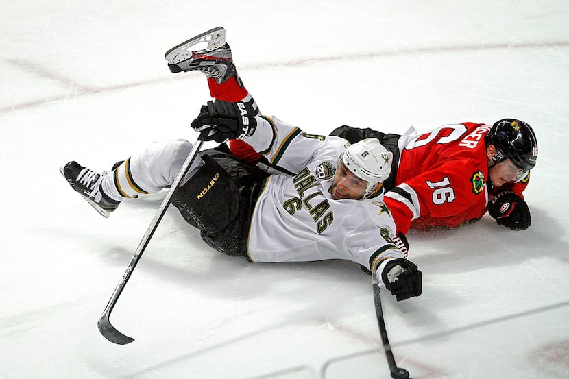 Chicago Blackhawks' Marcus Kruger (16) and Dallas Stars' Trevor Daley battle for the puck...
