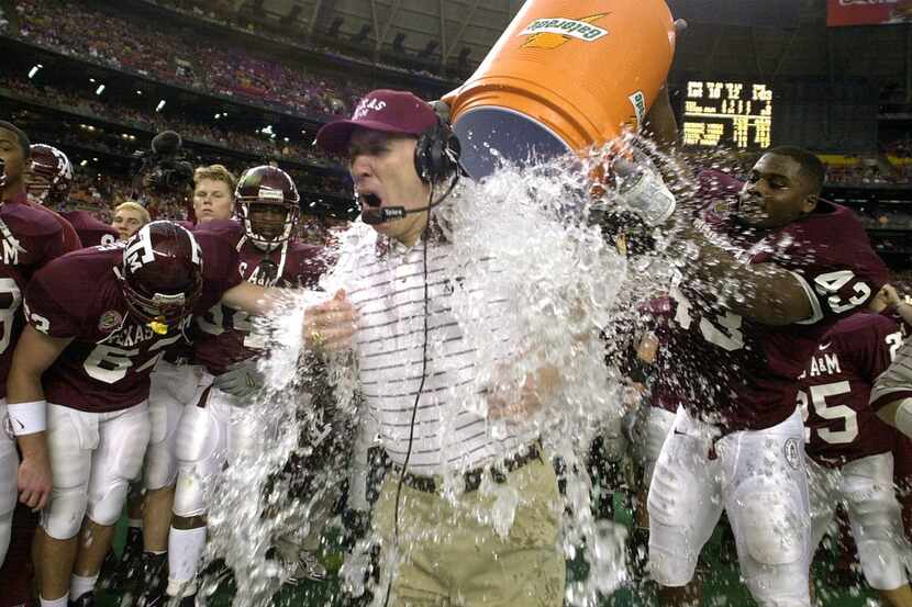 Texas A&M coach R.C. Slocum is dunked by players, including Jarrod Penright (43), during the...