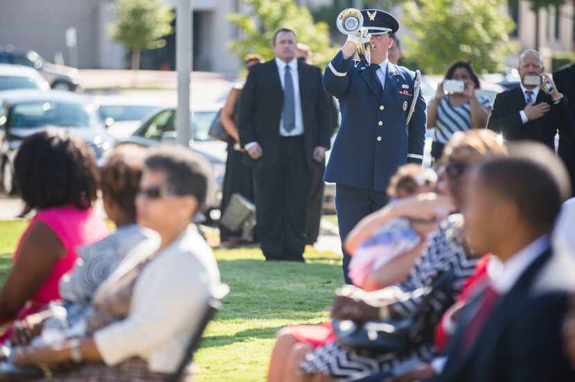 A member of a military honor guard plays a bugle during funeral services for retired Army...