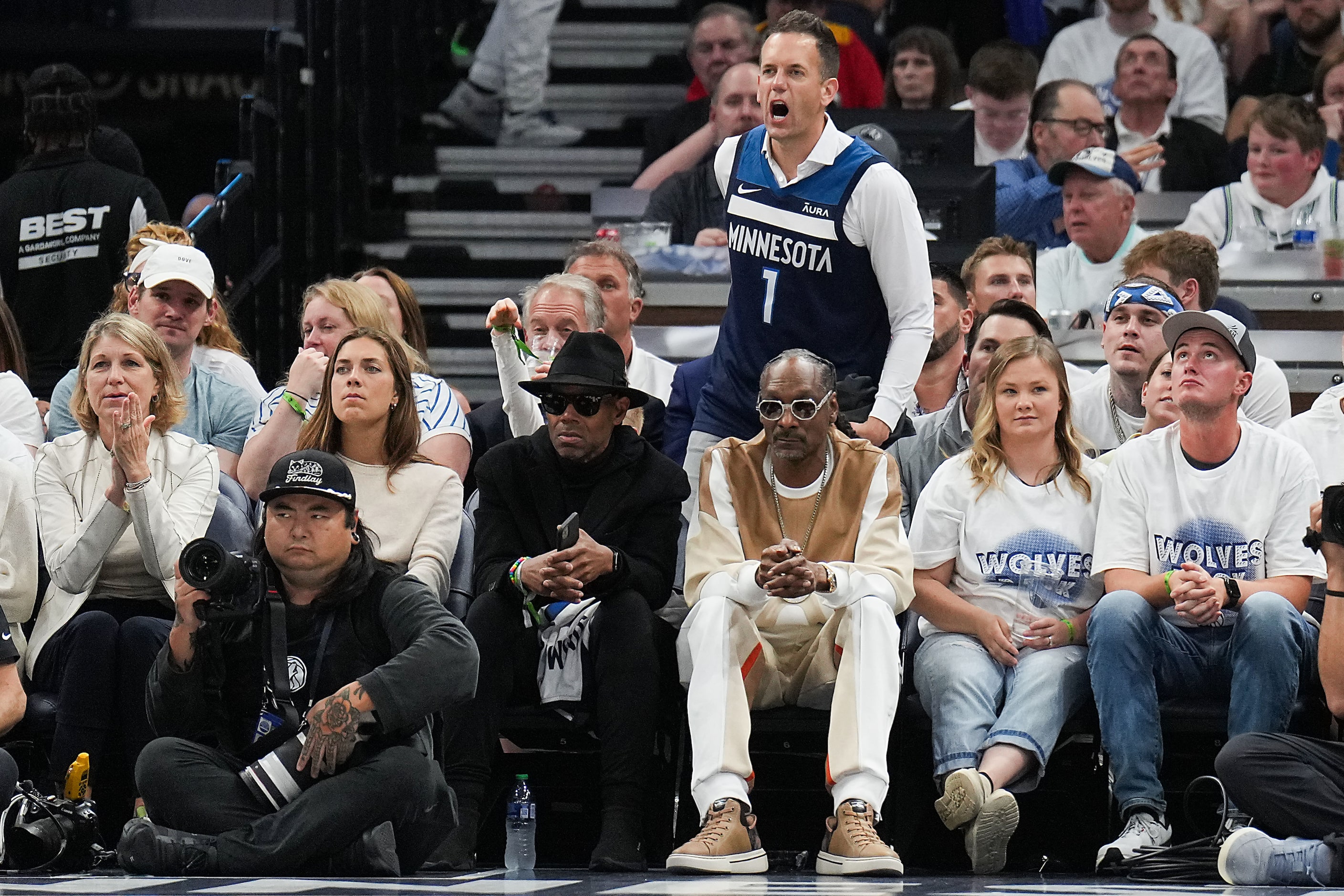 A Minnesota Timberwolves fan yells toward Dallas Mavericks guard Luka Doncic behind rapper...