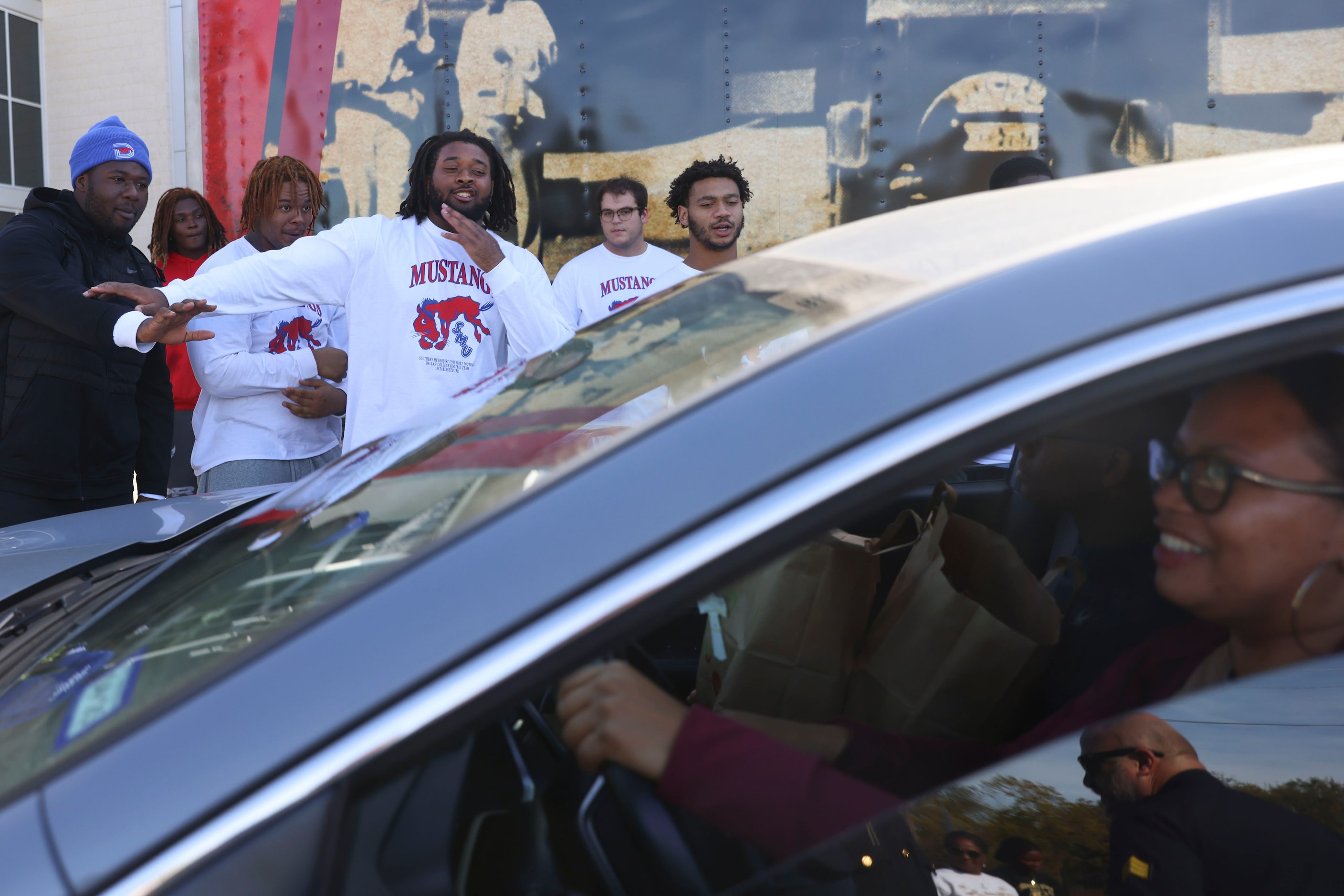 Southern Methodist University Alex Woods (center) and his teammates direct traffic during a...