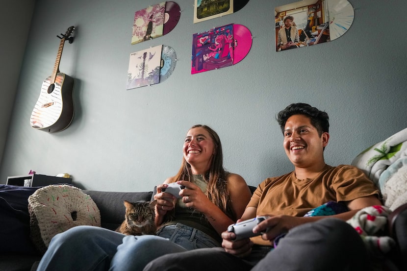 Natalie Taylor and Oscar Silva play video games together at their home on Monday, July 8,...