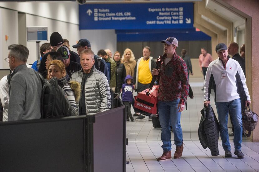 Travelers wait in line to go through a TSA security entrance in Terminal C at while others...