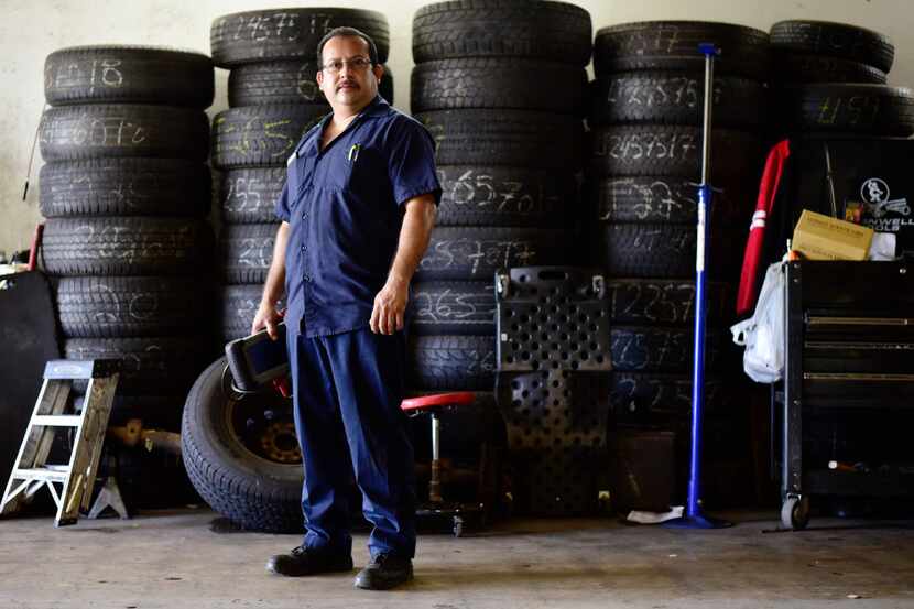 Joaquin Godinez poses at his auto mechanic shop in southeast Dallas.