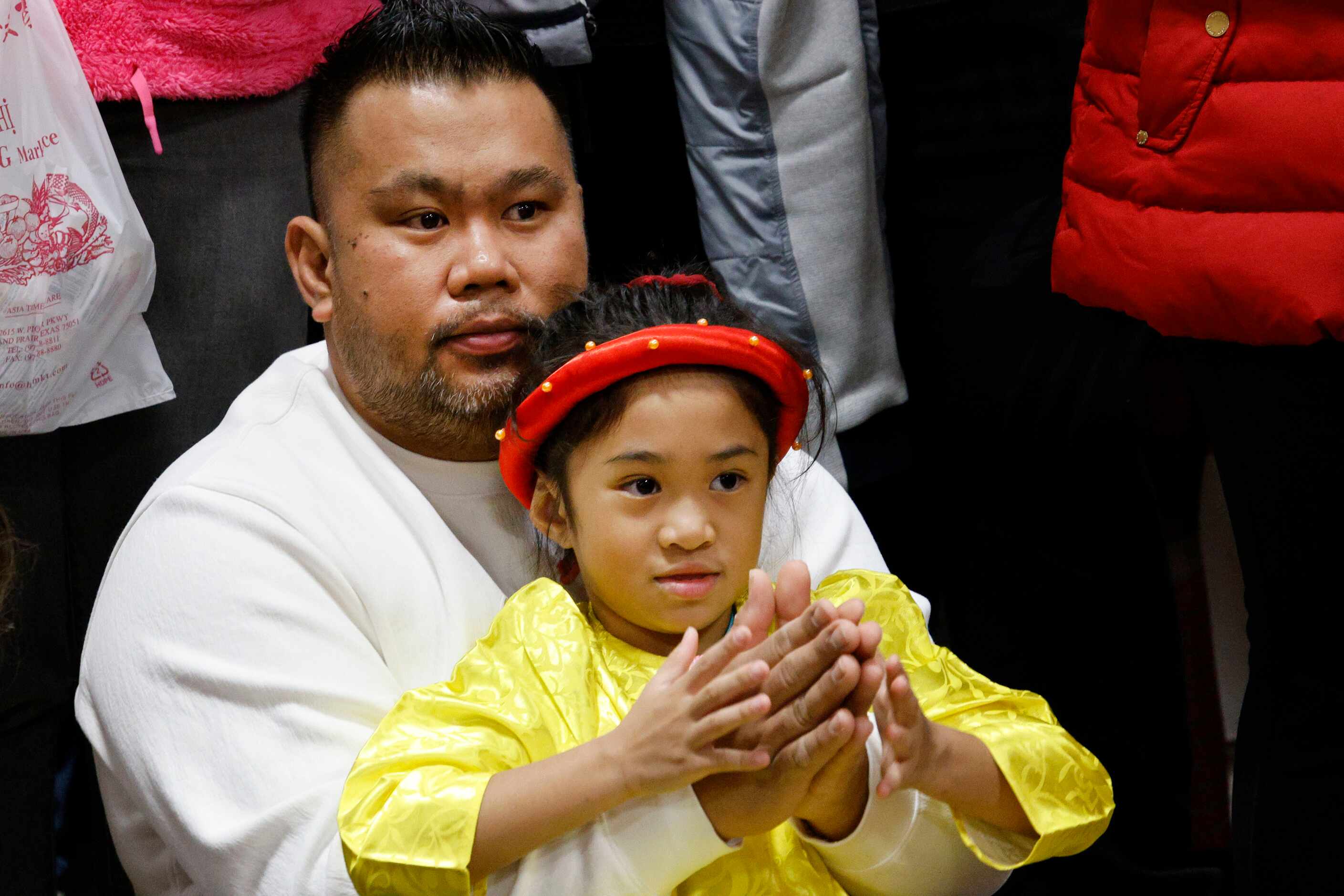 Lei Tomeldan, 6, of Grand Prairie waits for watching Lion dance performance with her father...