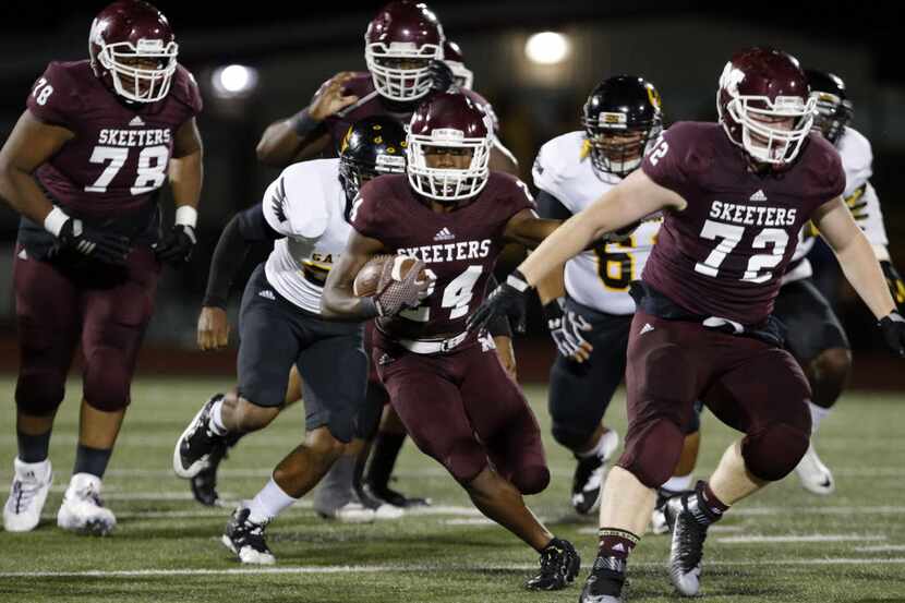 Mesquite's Chance Fisher (24) runs for a first down behind lineman Brendan Cherry (72)...