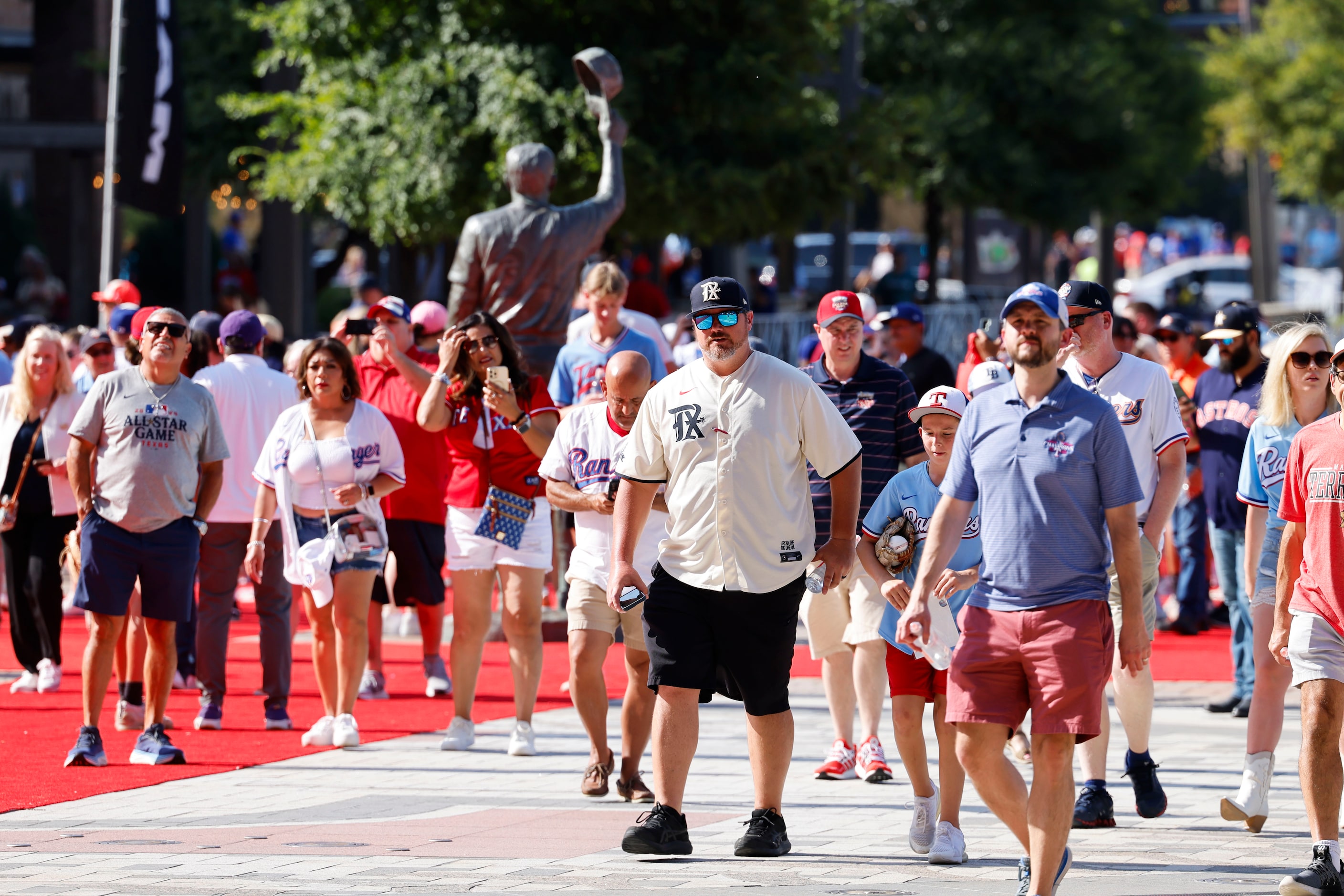 Fans make their way to the stadium ahead of the MLB All-Star baseball game, on Tuesday, July...