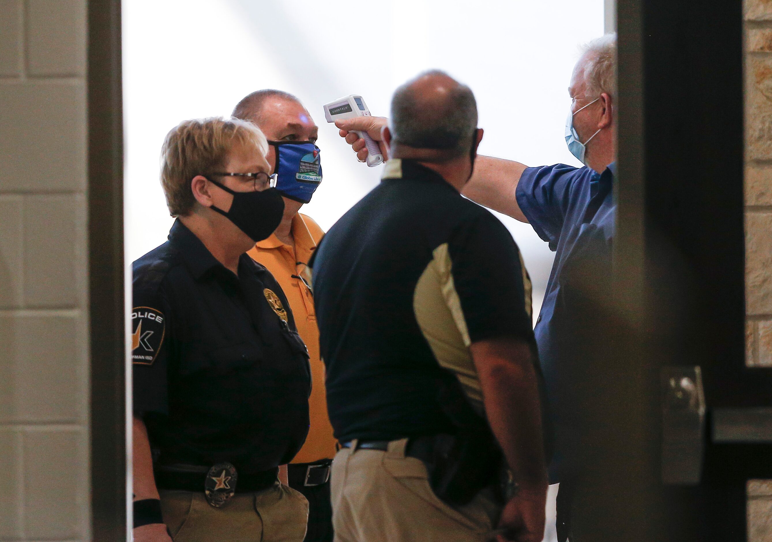 Event and security personnel are screened for fevers before a volleyball match between...