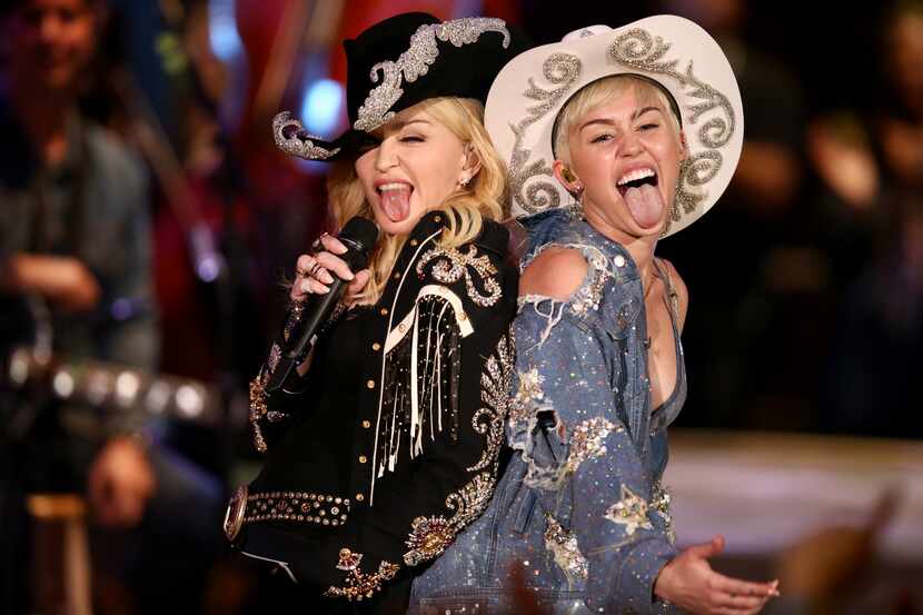 In this Tuesday, Jan. 28, 2014 photo provided by MTV, Miley Cyrus performs with Madonna...
