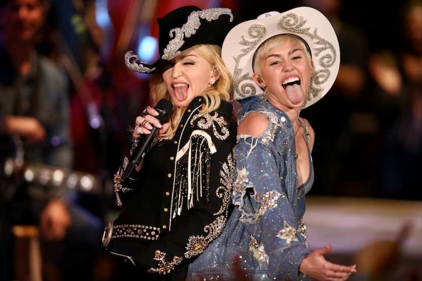 In this Jan. 28, 2014 photo provided by MTV, Miley Cyrus performs with Madonna during the...
