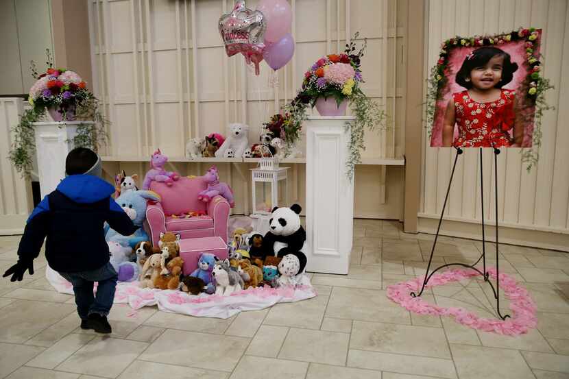 Aaron Gross, 3, runs up to a memorial for 3-year-old Sherin Mathews after an interfaith...