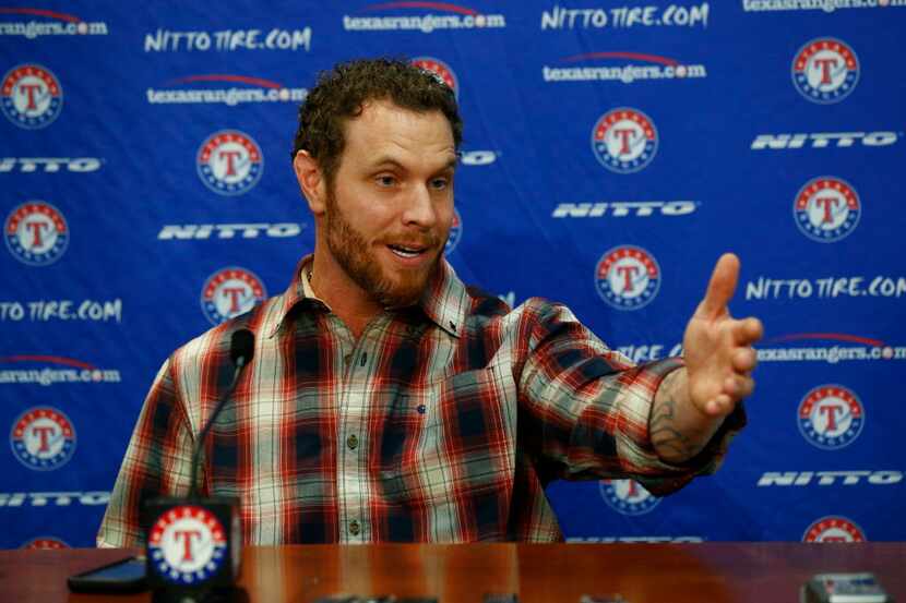 Josh Hamilton gestures during a press conference after signing with the Texas Rangers for...