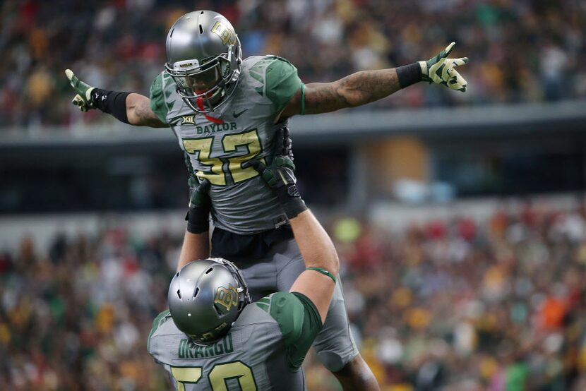 Baylor Bears offensive tackle Spencer Drango (58) lifts Baylor Bears running back Shock...