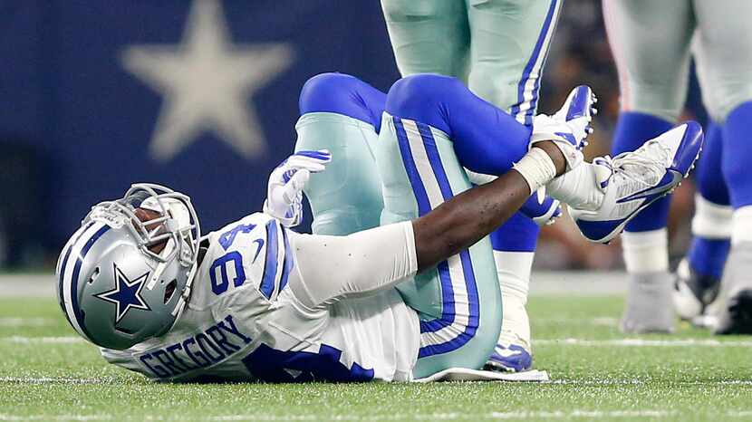 Dallas Cowboys defensive end Randy Gregory (94) holds his leg after suffering an injury...