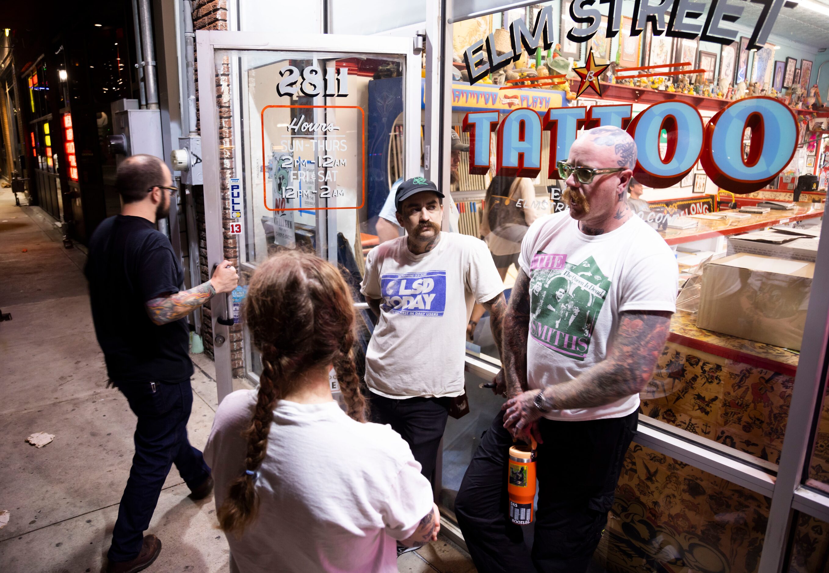 (Form left) Receptionist Kelsey Reynolds chats with tattoo artists Austin Gervais and Jacob...