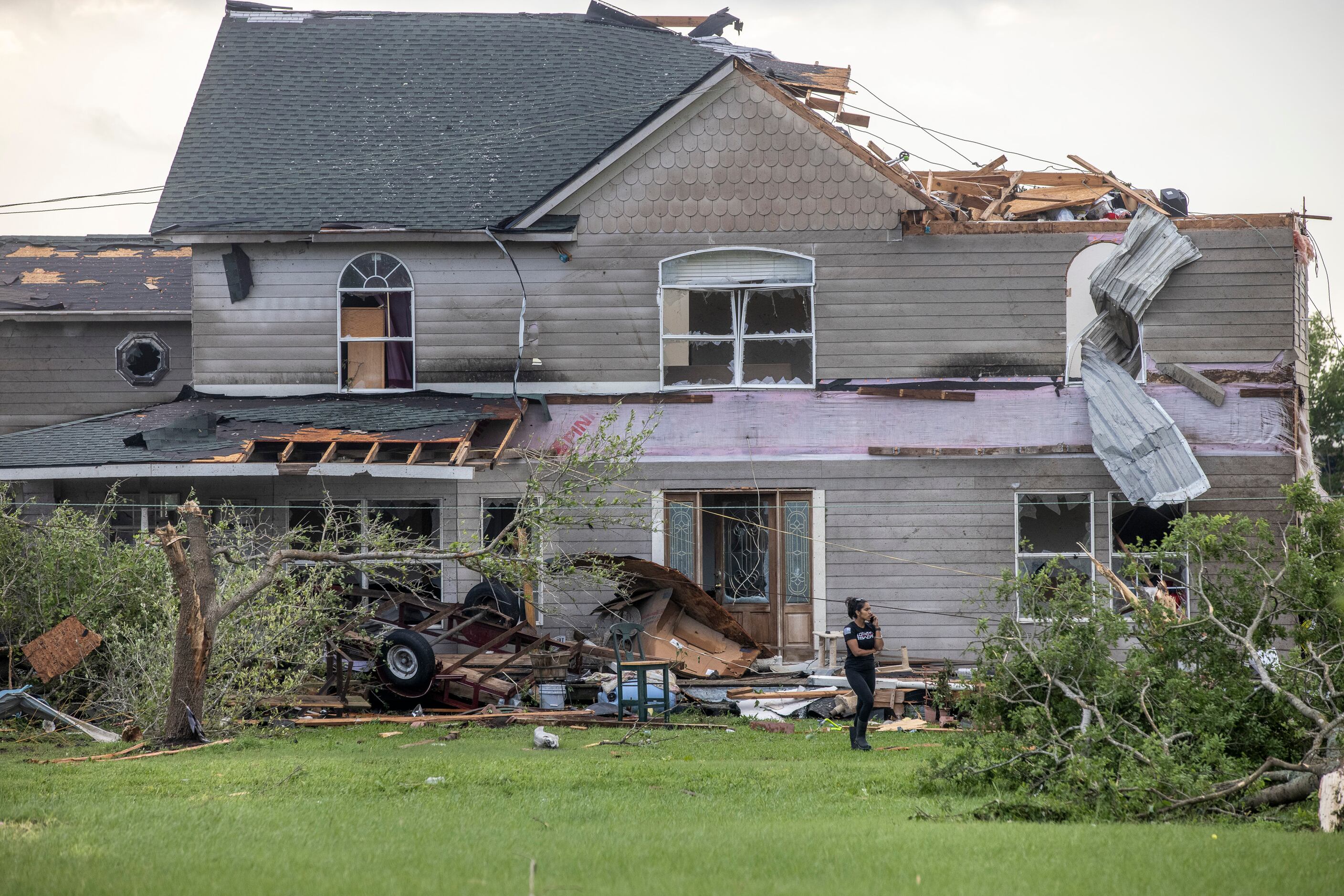 Monica Flores surveys the damage of her childhood family home in the aftermath of a Monday...