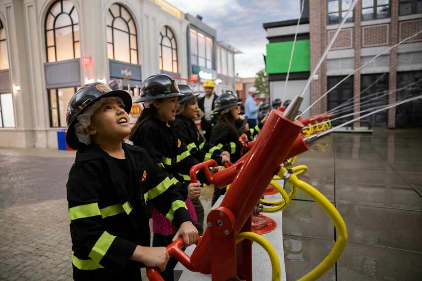 Nicholas Marquez (left), 8, helps douse a pretend fire at a birthday party at Kidzania in...