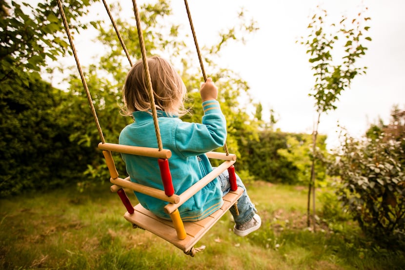 Child swinging on seesaw in backyard 