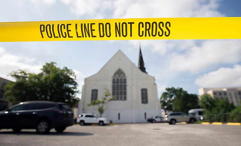 Police tape surrounds the parking lot Friday behind the AME Emanuel Church in Charleston,...