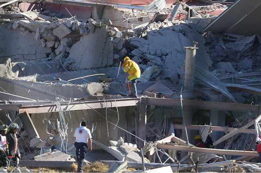 Rescuers work amid the wreckage after a gas explosion ripped through a children's hospital...