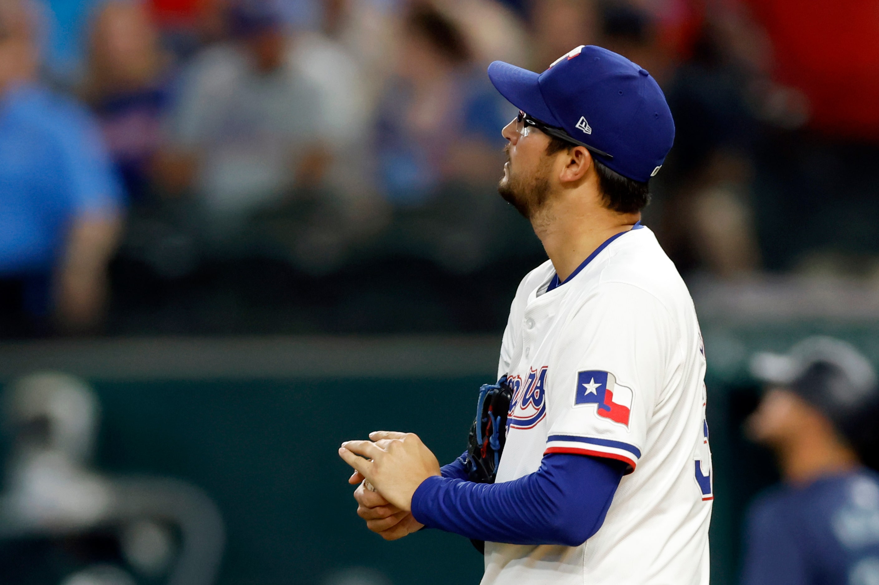 Texas Rangers starting pitcher Dane Dunning (33) watches a replay after giving up a lead-off...