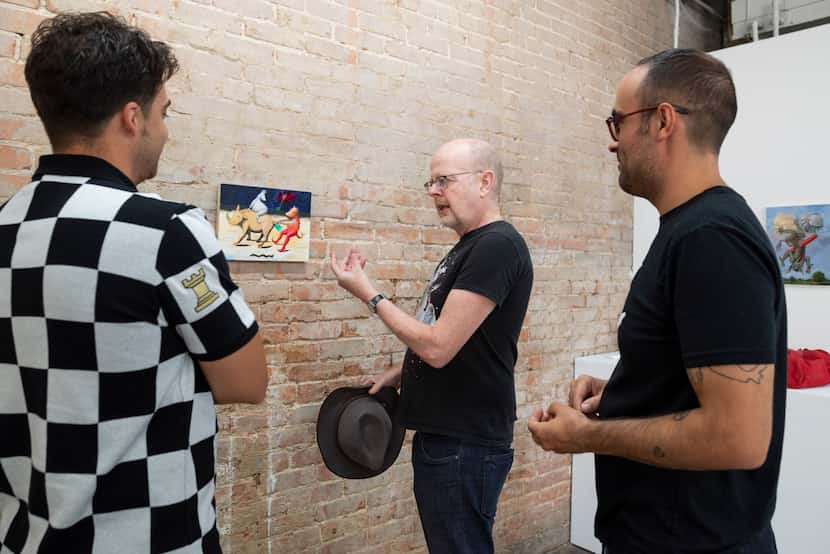 Artist and collector Ludwig Schwarz (center) speaks with gallery owner Kevin Rubén Jacobs...