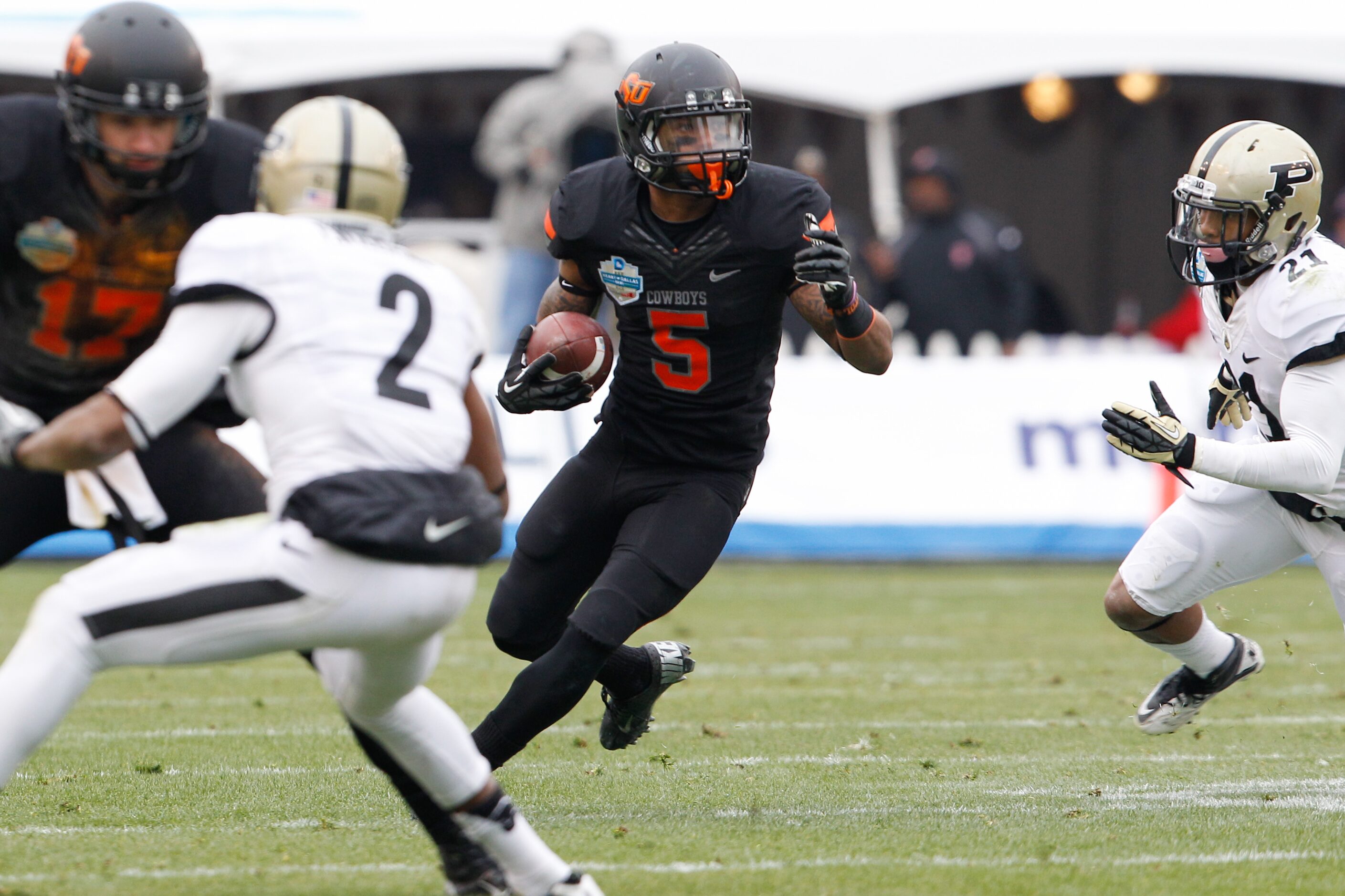 Oklahoma State's Josh Stewart (5) carries the ball down the field against Purdue during the...