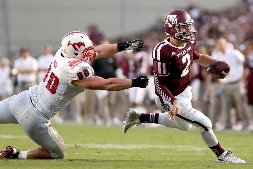 HOUSTON, TX- SEPTEMBER 21: Johnny Manziel #2 of the Texas A&M Aggies rushes past Zach Wood...