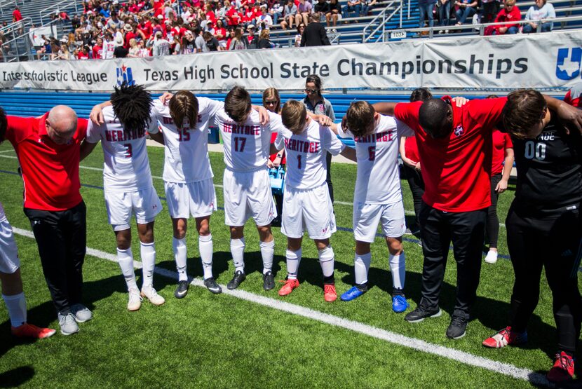 Midlothian Heritage players and coaches pray before of a UIL conference 4A boys state...