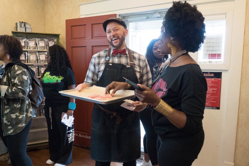 Clyde Greenhouse, owner of Kessler Baking Studio (center) hands out samples to attendees of...
