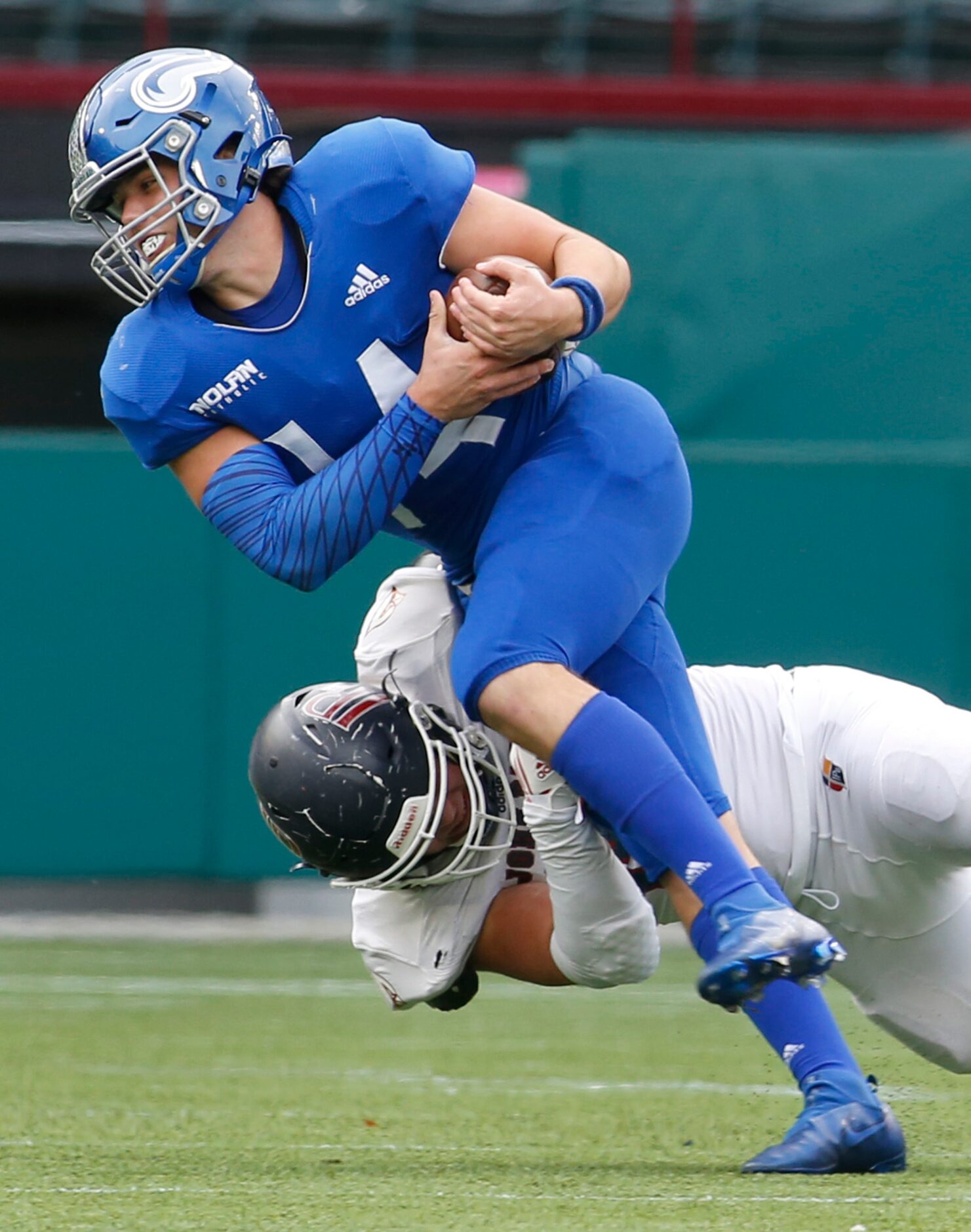 Fort Worth Nolan quarterback Jimmy Taylor (14) is unable to elude the tackle of Plano John...