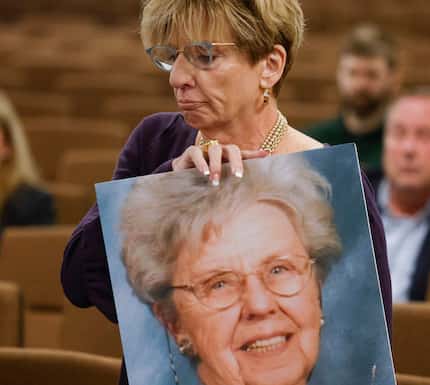 Shannon Dion, daughter of victim Doris Gleason holds a photo of her mother as she delivers...