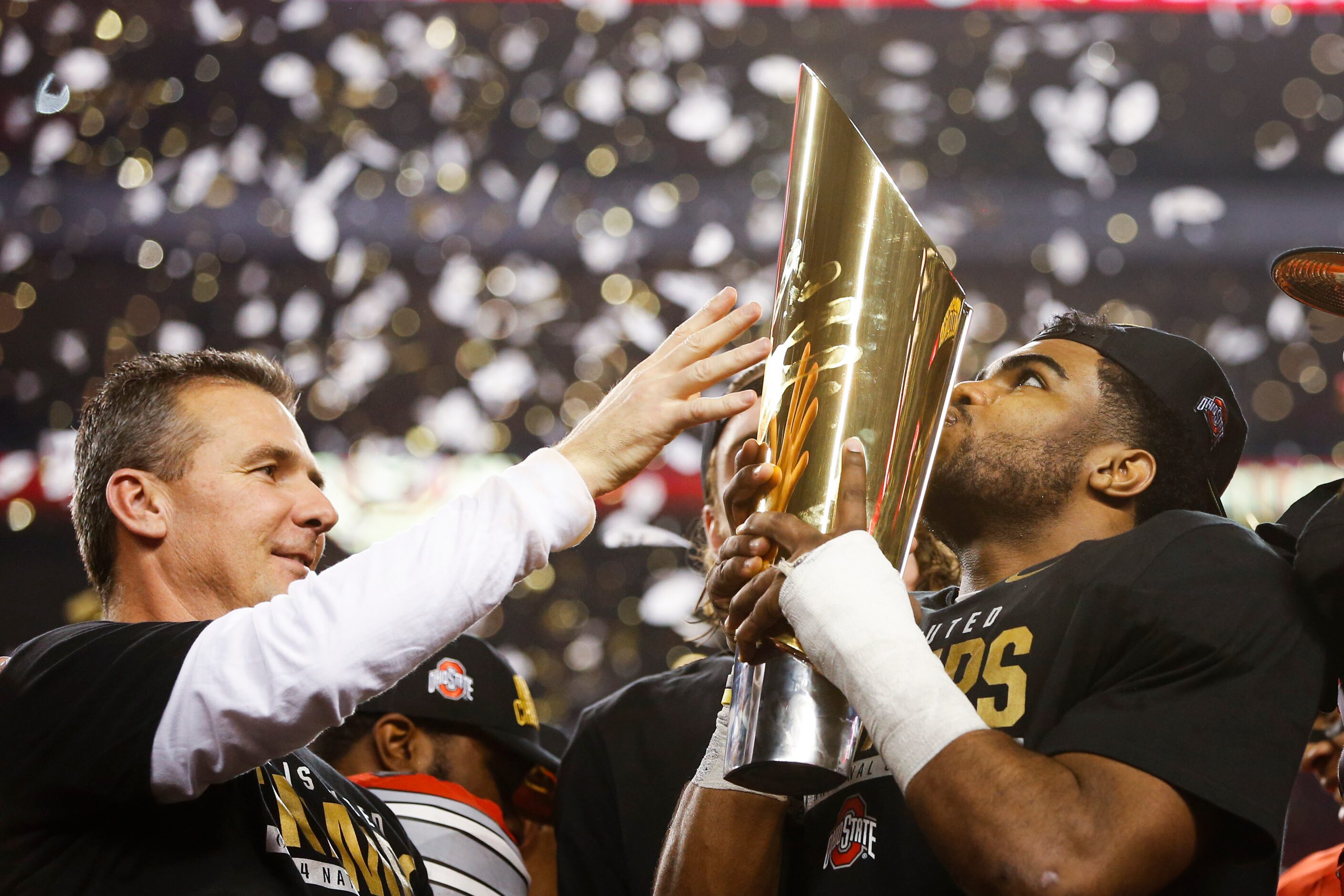 Ohio State Buckeyes head coach Urban Meyer watches as the  championship trophy is kissed by...