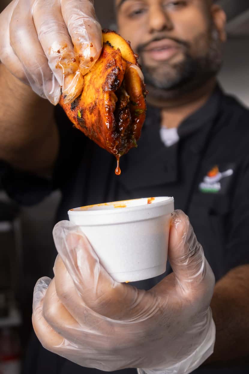 Halal Fusionz owner Ahmed Siyaji holds a Nihari X Birria Taco, which is made with Pakistani...