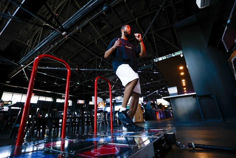 Silas Greene lifts his feet as he moves between the arrows of a Dance Dance Revolution...