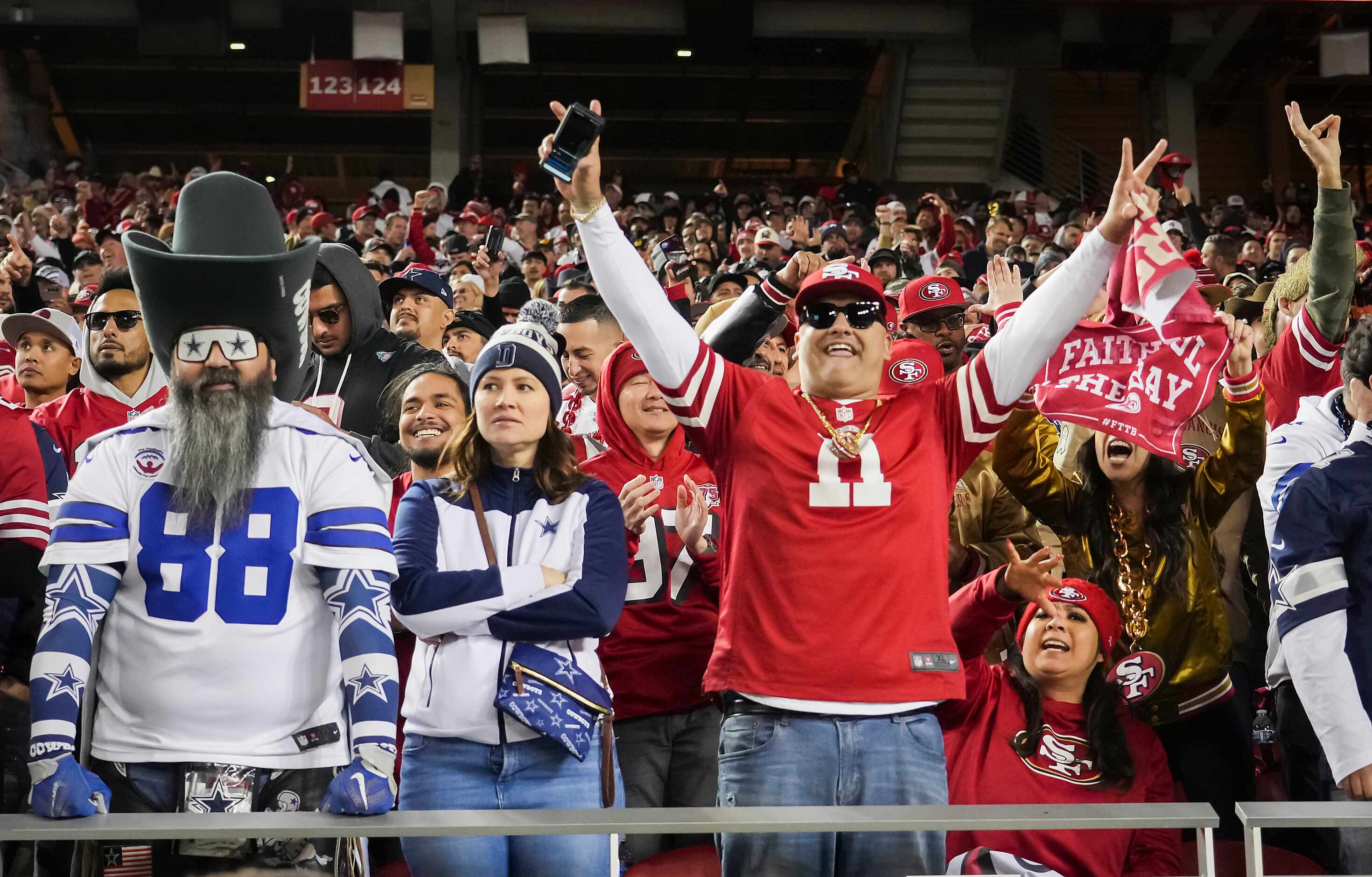 Dallas Cowboys fans look away as San Francisco 49ers fans celebrate a touchdown run by 49ers...