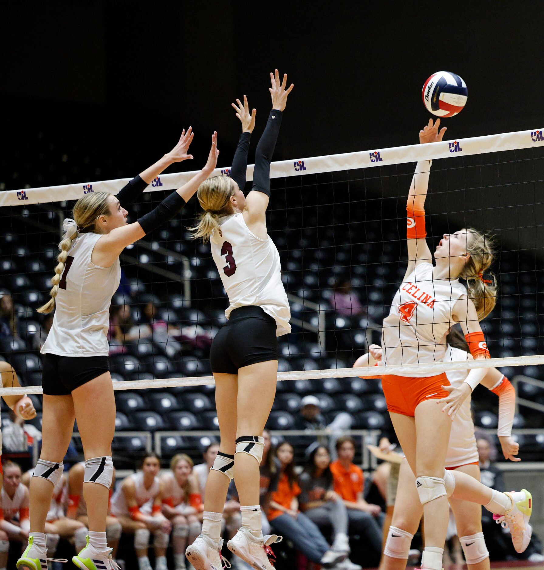 Celina's Selah Nickel (4) spikes the ball past Comal Davenport's Morgan Pelech (1) and Comal...