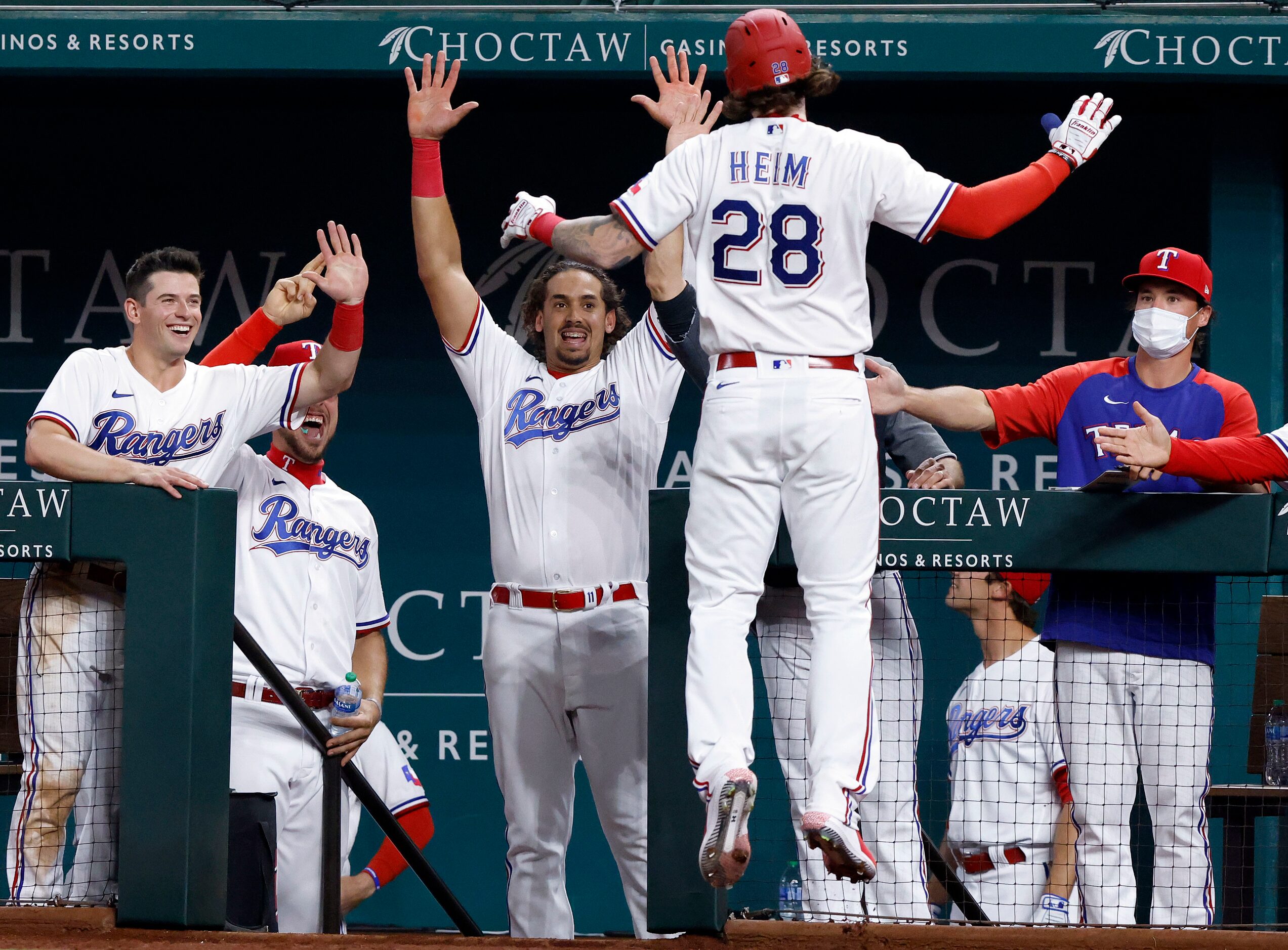 Texas Rangers Jonah Heim (28) is congratulated by teammates after hitting his first Major...